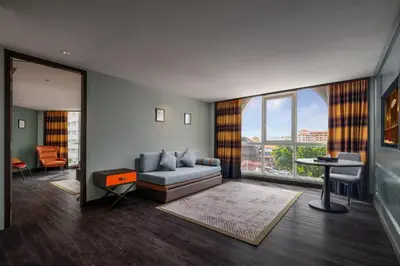 a living room with a couch and a large window at The George Penang by The Crest Collection in George Town