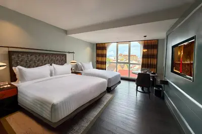 a hotel room with two beds and a window at The George Penang by The Crest Collection in George Town