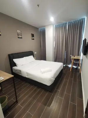 a bedroom with a bed and a wooden floor at Hotel Mutiara in Gua Musang