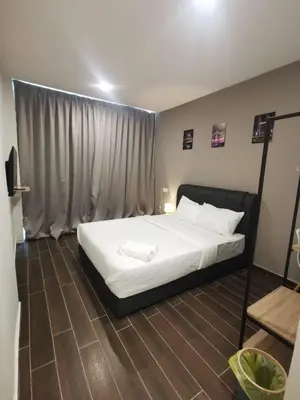 a bedroom with a bed with white sheets and a window at Hotel Mutiara in Gua Musang