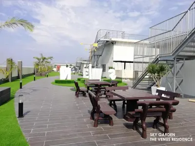 a patio with wooden tables and benches on a building at Venus Hollywood Homestay Sitiawan in Seri Manjung