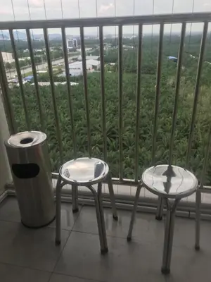 two chairs and a trash can in front of a window at Venus Hollywood Homestay Sitiawan in Seri Manjung