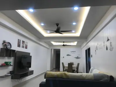 a living room with a couch and a tv and a table at Venus Hollywood Homestay Sitiawan in Seri Manjung