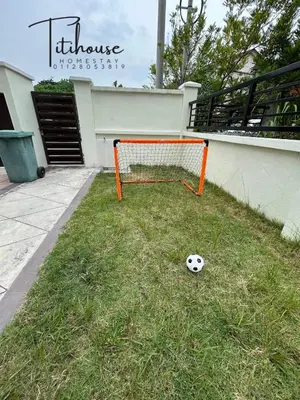 a soccer ball sitting on the grass next to a goal at Titihouse Semi-D for 14 pax near Iconvcity Auto city Bukit Mertajam Juru in Bukit Mertajam