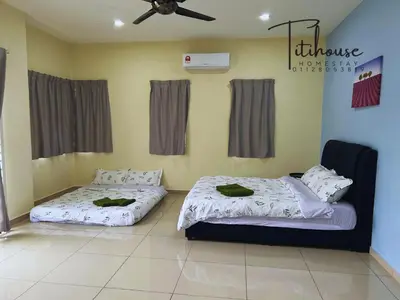 two beds in a room with a ceiling fan at Titihouse Semi-D for 14 pax near Iconvcity Auto city Bukit Mertajam Juru in Bukit Mertajam