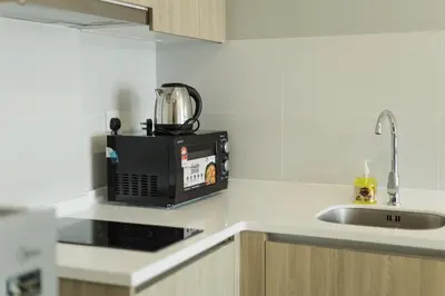a microwave sitting on a kitchen counter next to a sink at The Palm, 2BR Cityview by WStay @ Tropicana 218 Macalister in George Town