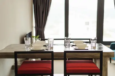 a dining room table with two chairs and a table with plates and glasses at The Palm, 2BR Cityview by WStay @ Tropicana 218 Macalister in George Town