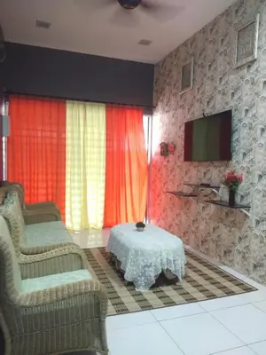 a living room with two chairs and a table and a television at Tuah Homestay Musleem Only in Chemor