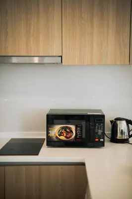 a microwave oven sitting on top of a kitchen counter at The Pine, 3BR Seaview by WStay @ Tropicana 218 Macalister in George Town
