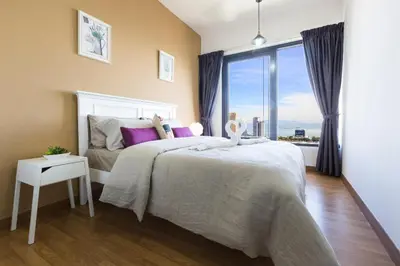 a bedroom with a large bed and a large window at The Ash, 3BR Seaview by WStay @ Tropicana 218 Macalister in George Town