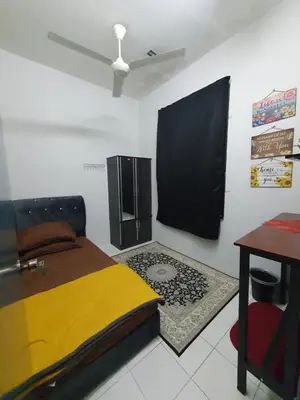 a bedroom with a bed and a desk and a table at LH Alisha Homestay Wangsa Mewangi Gua Musang in Gua Musang