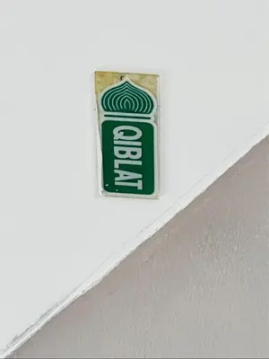 a green soda can sign on a white wall at Batu Feringgi Homestay in Batu Ferringhi