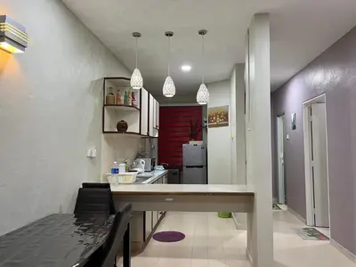a kitchen with a long counter in a room at Batu Feringgi Homestay in Batu Ferringhi