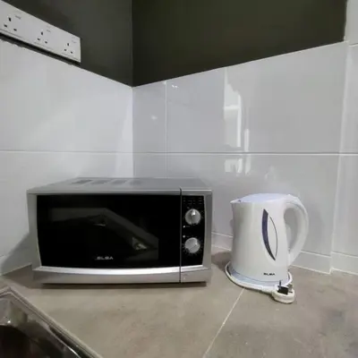 a microwave sitting on top of a kitchen counter at 191 Cozy Casa Kayangan 3BR 6pax by Grab A Stay in Ipoh
