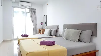 two beds in a bedroom with purple pillows on them at Mansion One Entire House 4 QueenBeds - Spacious Balcony Seaview in George Town