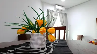 a vase with orange flowers sitting on a table at Mansion One Entire House 4 QueenBeds - Spacious Balcony Seaview in George Town
