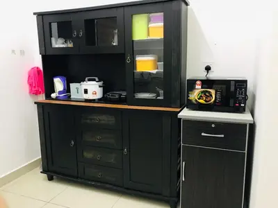 a black cabinet with a microwave in a kitchen at MMG D'Bertam Homestay For Malay Only in Kampong Permatang Durian