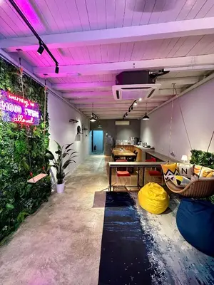 a room with a table and some plants and purple lights at Swing & Pillows @ Beach Street in George Town