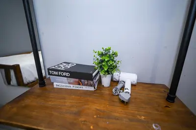 a table with two books and a camera and a plant at Swing & Pillows @ Beach Street in George Town