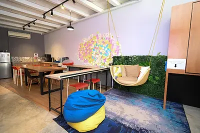 a room with a table and chairs and a swing at Swing & Pillows @ Beach Street in George Town