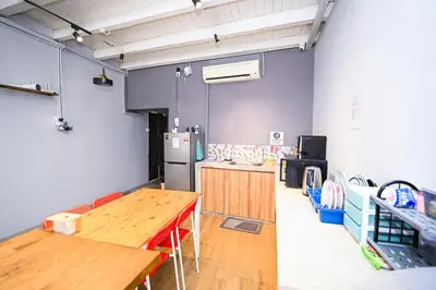 a kitchen with a wooden table and a refrigerator at Swing & Pillows @ Beach Street in George Town