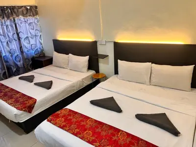 two beds in a hotel room with pillows on them at Hotel Citra in Brinchang