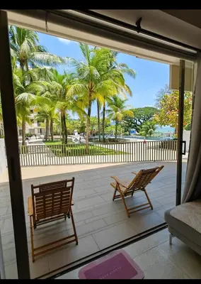 a patio with two chairs and palm trees at By The Sea Batu Ferringhi Beach Front, Seaview And Pool Front in Batu Ferringhi