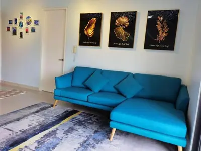 a living room with a blue couch and a rug at WOODSBURY PREMIER LUXURY SUITE 2B2R 2MIN SUNWAY in Butterworth