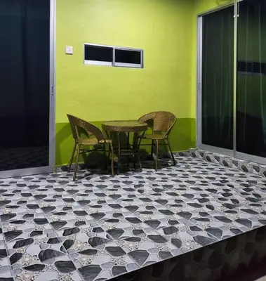a patio with a table and chairs on a tiled floor at Inap Desa 3 in Kampong Siput