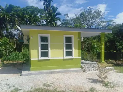 a tiny house with a yellow and green exterior at Inap Desa 3 in Kampong Siput