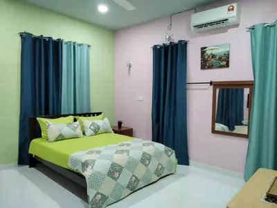a bedroom with a green bed and blue curtains at Inap Desa 1 in Kampong Siput