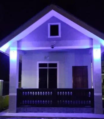 a house with purple lights in front of it at Inap Desa 1 in Kampong Siput