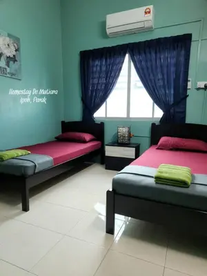 a bedroom with two beds and a window at Homestay De Mutiara Tasek Ipoh in Ipoh