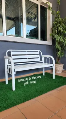 a white bench sitting in front of a building at Homestay De Mutiara Tasek Ipoh in Ipoh