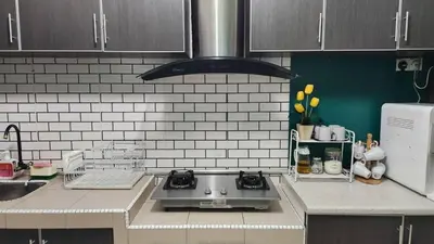 a kitchen with a stove top oven in a kitchen at Homestay De Mutiara Tasek Ipoh in Ipoh