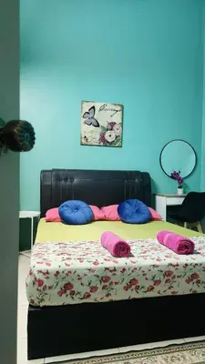 a bed with pillows on it in a room at Homestay De Mutiara Tasek Ipoh in Ipoh