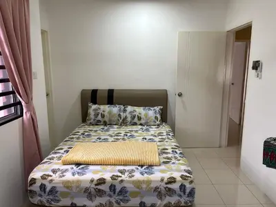 a bedroom with a bed with a comforter on it at D’sayang homestay klebang ipoh in Ipoh
