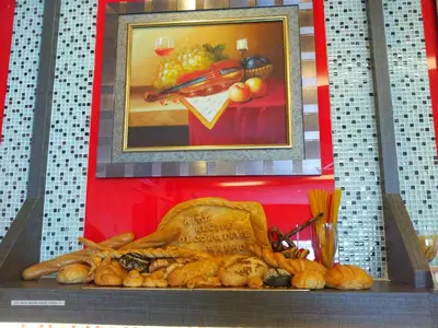 a display of food on a shelf with a painting at Ritz Garden Hotel Manjung in Lumut
