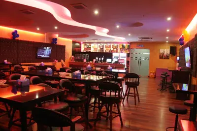 a restaurant with tables and chairs and a bar at Ritz Garden Hotel Manjung in Lumut