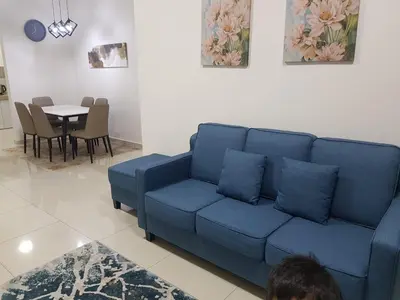 a blue couch in a living room with a table at D' Homestay Meru Ipoh - Free WiFi in Ipoh