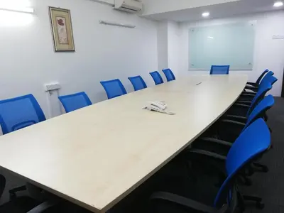 a conference room with a long table and blue chairs at Hotel Damai in Parit Buntar