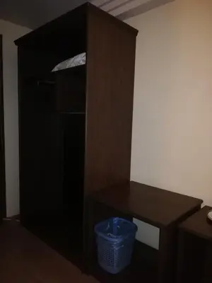 a dark wooden cabinet with a basket in a room at Hotel Damai in Parit Buntar