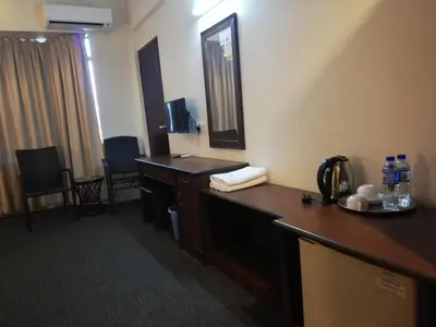 a hotel room with a desk and a mirror at Hotel Damai in Parit Buntar