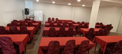 an empty room with red tables and chairs at Hotel Damai in Parit Buntar
