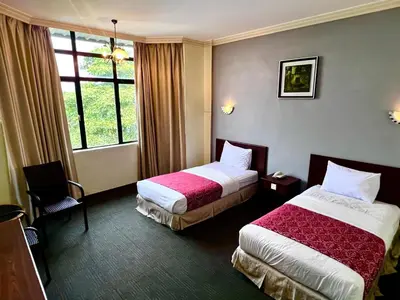 a hotel room with two beds and a window at Hotel Damai in Parit Buntar