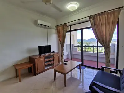 a living room with a tv and a couch and a table at My Getaway Home @Marina Cove in Lumut
