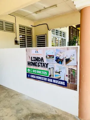 a sign on a wall in front of a house at LH Homestay Bandar Utama Gua Musang in Gua Musang