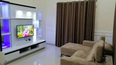 a living room with a tv and a couch at Rumah Hana Sungai Besar - Mslim0nly in Sungai Besar