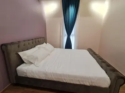 a bed with white sheets and a blue curtain at The Cove Hillside Condominium in Ipoh