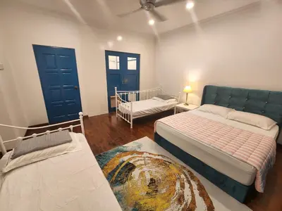 a bedroom with two beds and a couch in it at Solok Burma Vacation Home @ Gurney Penang in George Town